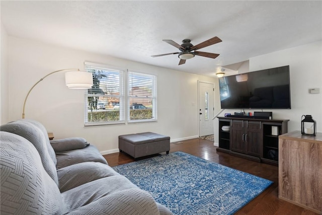 living room featuring ceiling fan and dark wood-type flooring