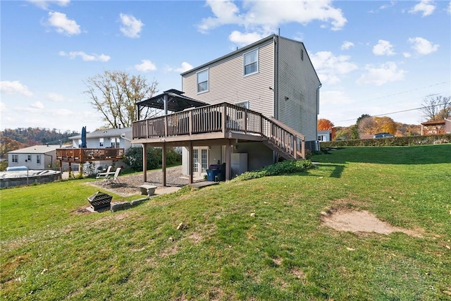 back of property featuring a lawn, an outdoor fire pit, and a wooden deck