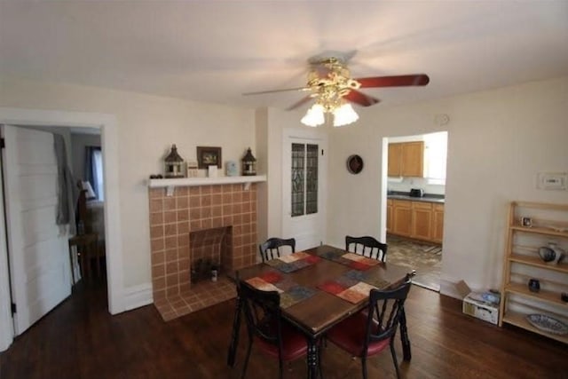 dining room with a tile fireplace, dark hardwood / wood-style flooring, and ceiling fan