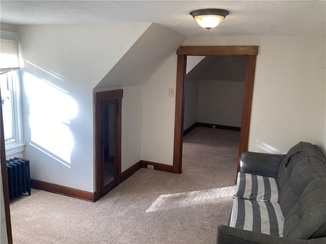 bonus room featuring radiator, light carpet, and lofted ceiling