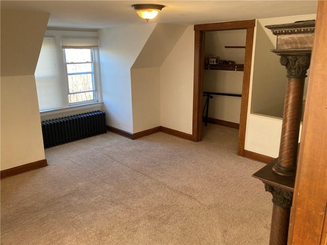 additional living space with radiator, light carpet, and lofted ceiling