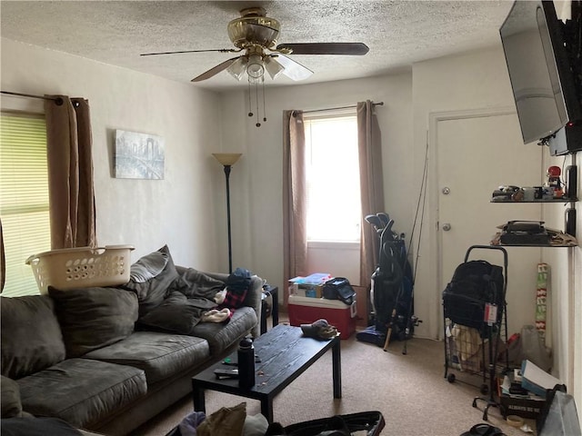 living room featuring ceiling fan, light colored carpet, and a textured ceiling