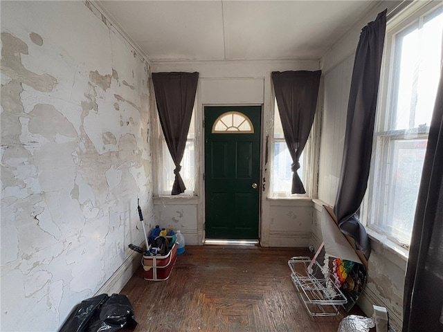 foyer with parquet floors, a healthy amount of sunlight, and ornamental molding