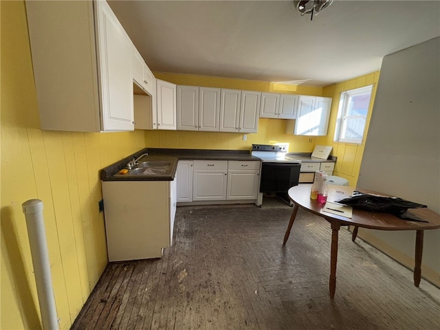 kitchen with white cabinets, white range with electric stovetop, dark hardwood / wood-style flooring, and sink