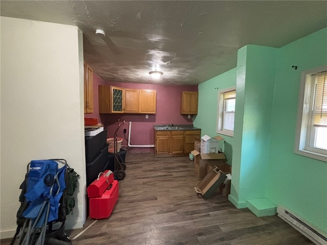 kitchen featuring dark hardwood / wood-style floors, a baseboard heating unit, and sink