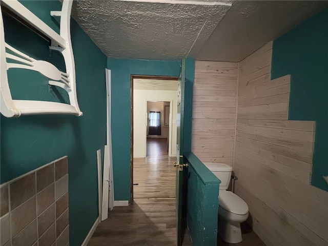 corridor featuring wood-type flooring and a textured ceiling