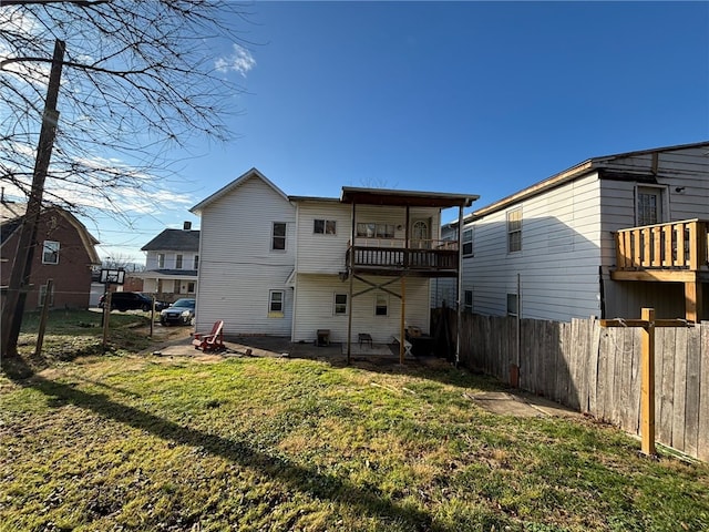 rear view of property with a balcony and a lawn