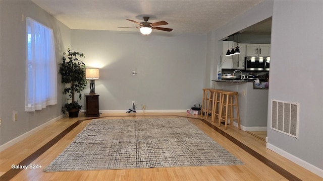 sitting room featuring ceiling fan and light wood-type flooring