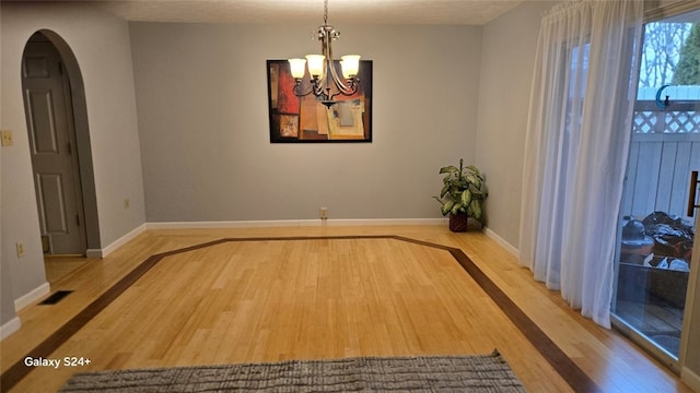 interior space with wood-type flooring and an inviting chandelier