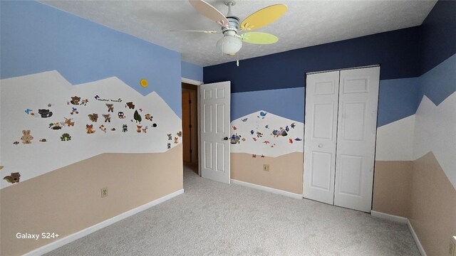 unfurnished bedroom with ceiling fan, a closet, light colored carpet, and a textured ceiling