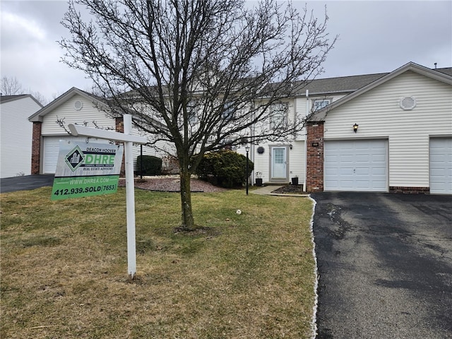 exterior space featuring a garage and a front lawn