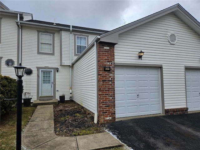 townhome / multi-family property featuring a garage and brick siding