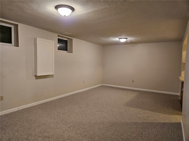 basement featuring carpet and a textured ceiling