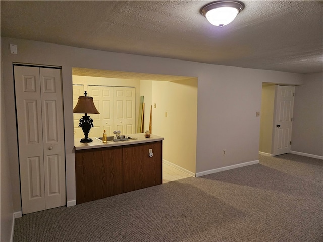 spare room featuring light carpet and a textured ceiling