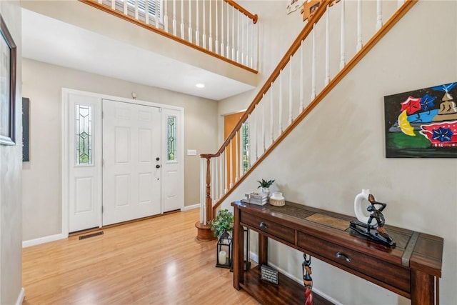 entrance foyer with a high ceiling and light hardwood / wood-style flooring