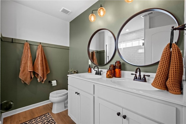 bathroom featuring vanity, toilet, wood-type flooring, and walk in shower