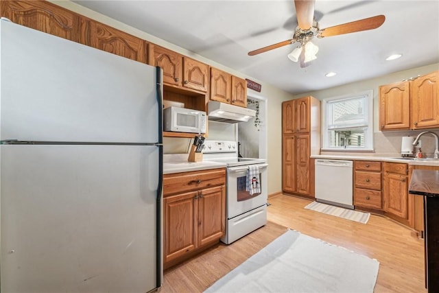 kitchen with ceiling fan, sink, light hardwood / wood-style floors, and white appliances