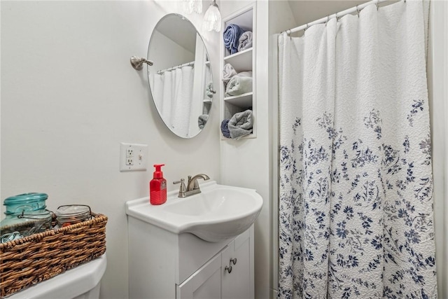 bathroom with toilet, vanity, and a shower with shower curtain