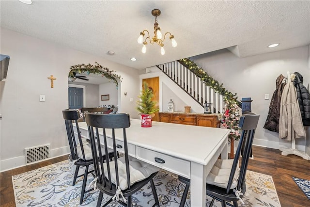 dining room featuring a chandelier, a textured ceiling, and dark hardwood / wood-style floors