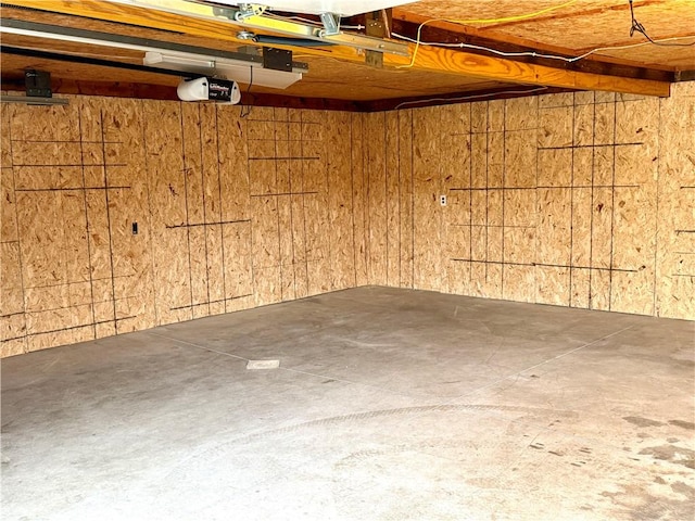 garage with a garage door opener and wooden walls