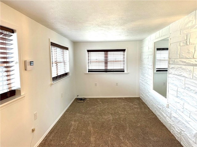 carpeted spare room with a textured ceiling