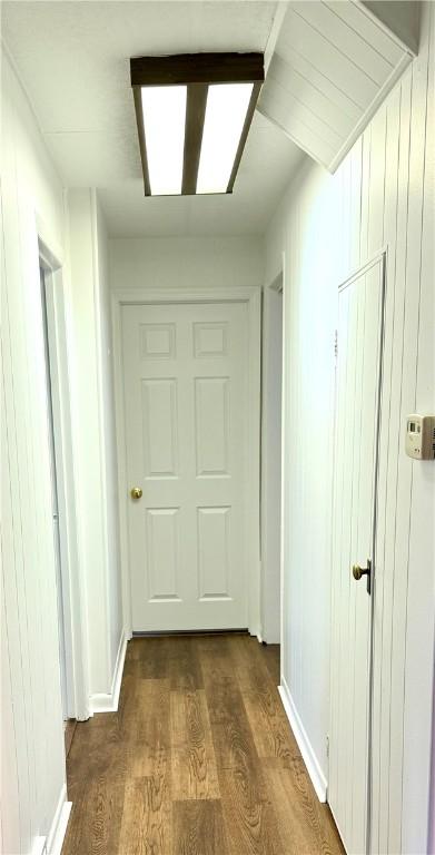 hallway with dark hardwood / wood-style floors