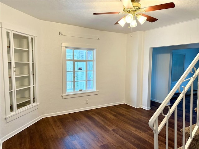 empty room featuring ceiling fan and dark hardwood / wood-style floors