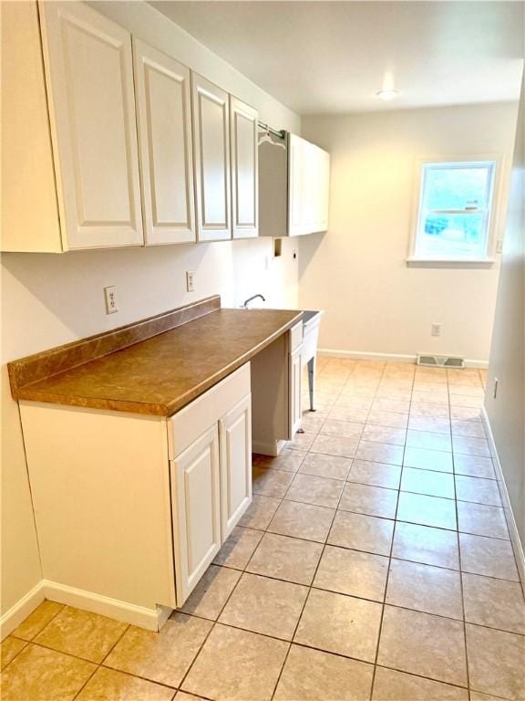 kitchen featuring white cabinetry and light tile patterned floors