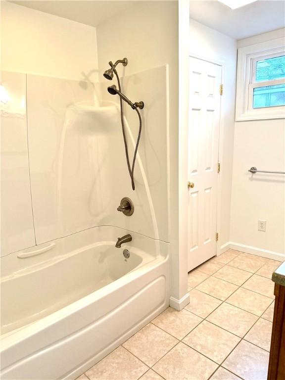 bathroom with tile patterned flooring, bathtub / shower combination, and vanity