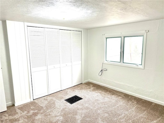 unfurnished bedroom featuring carpet floors and a textured ceiling