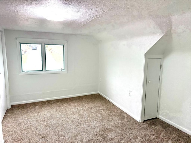 empty room with carpet flooring and a textured ceiling