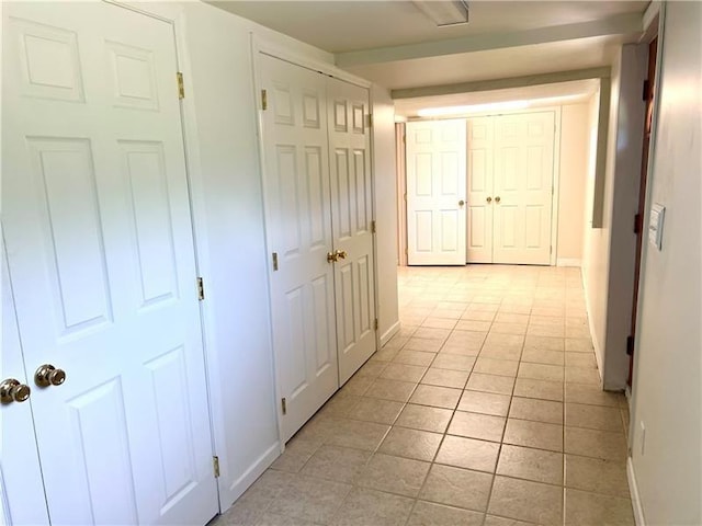 hall with light tile patterned floors