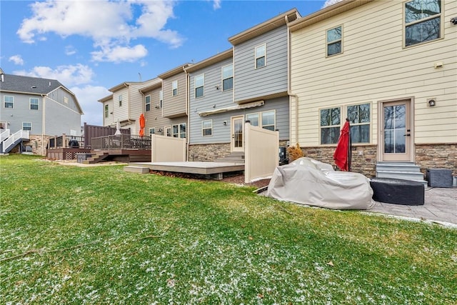 back of house featuring a deck and a yard