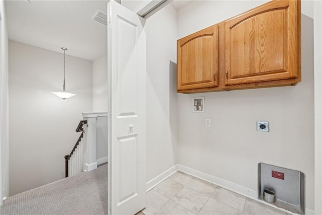 clothes washing area with electric dryer hookup, hookup for a washing machine, and cabinets