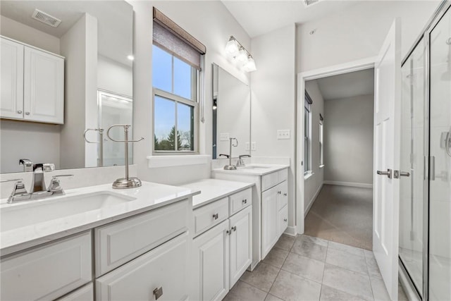 bathroom with tile patterned flooring, vanity, and a shower with door