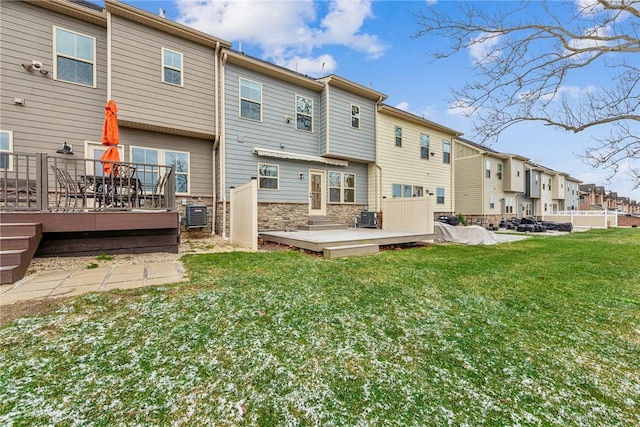 back of property featuring a yard, a wooden deck, and central AC