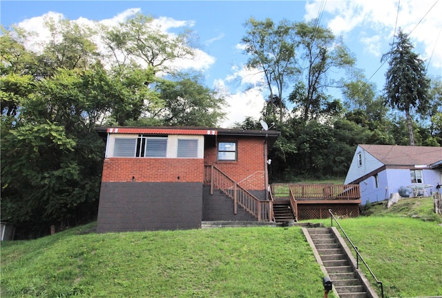 rear view of house featuring a lawn and a deck