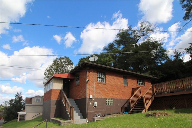 rear view of house with a lawn and a wooden deck