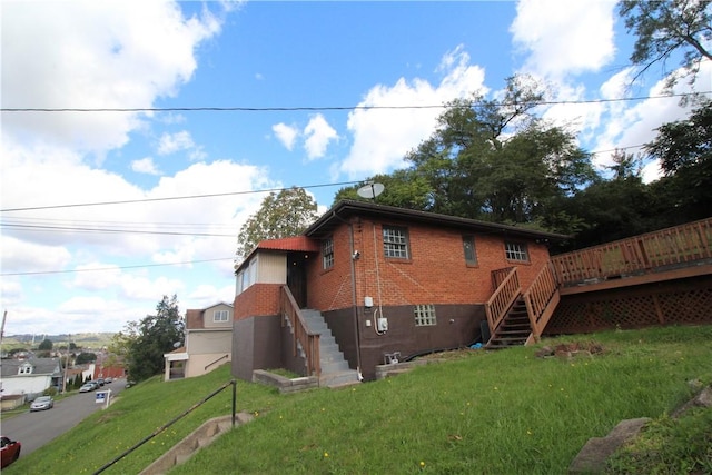 view of side of property with a lawn and a wooden deck