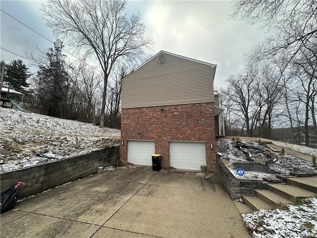 view of snowy exterior featuring a garage