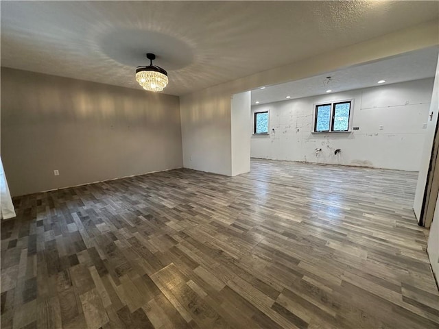 spare room with a chandelier and wood-type flooring