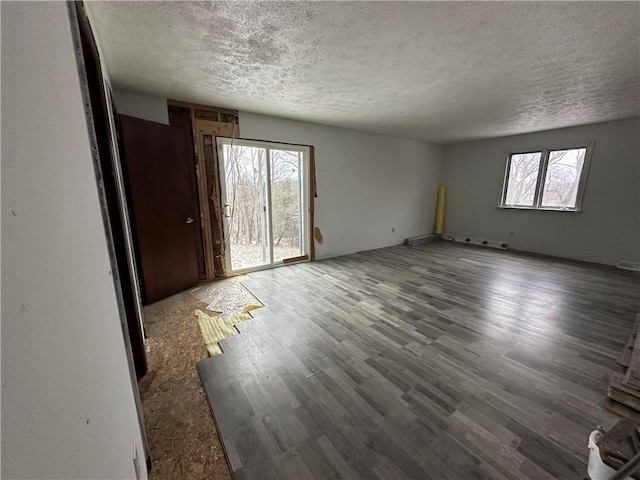 unfurnished room featuring hardwood / wood-style flooring and a textured ceiling