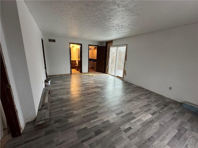 unfurnished room featuring dark hardwood / wood-style flooring and a textured ceiling