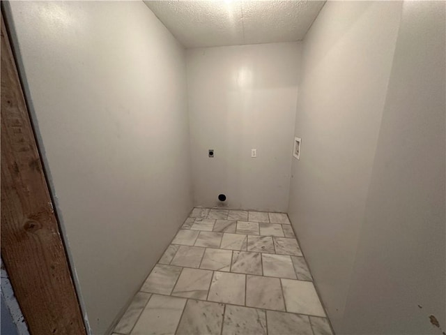 laundry room featuring hookup for a washing machine, a textured ceiling, and electric dryer hookup