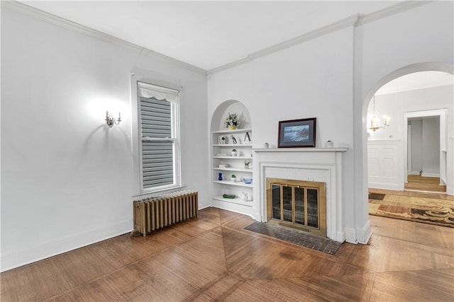 unfurnished living room featuring built in shelves, radiator heating unit, and crown molding