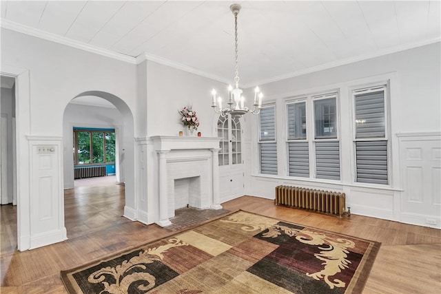 living room featuring a fireplace, radiator heating unit, ornamental molding, and hardwood / wood-style floors