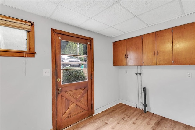 clothes washing area featuring cabinets and light hardwood / wood-style floors