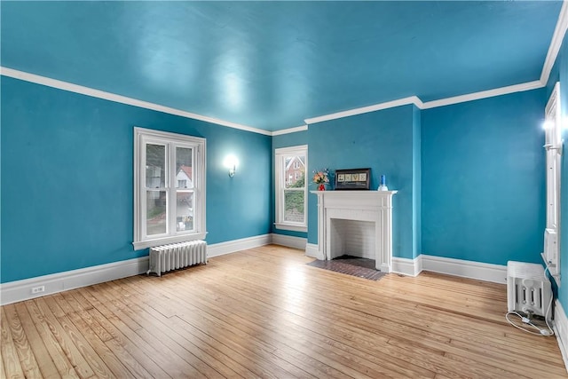 unfurnished living room with light hardwood / wood-style floors, radiator heating unit, and ornamental molding