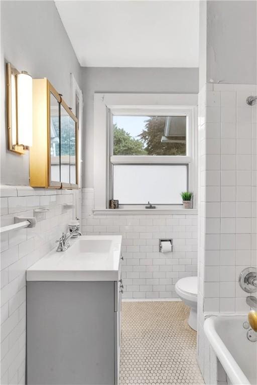 full bathroom with bathtub / shower combination, vanity, tile walls, tile patterned flooring, and toilet