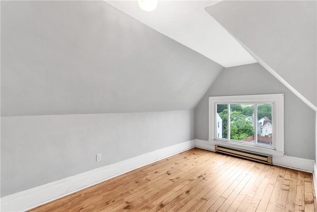 bonus room featuring a baseboard radiator, vaulted ceiling, and light wood-type flooring